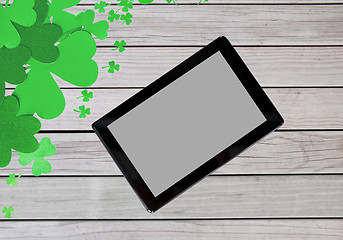 Image showing tablet pc and st patricks day decorations on wood