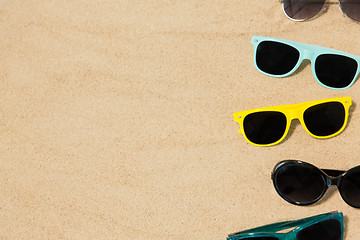 Image showing different sunglasses on beach sand