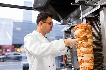 Image showing chef slicing doner meat from spit at kebab shop