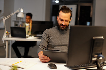 Image showing creative man with computer working late at office