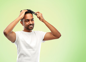 Image showing happy indian man brushing hair with comb