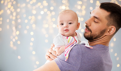 Image showing father with little baby daughter over lights