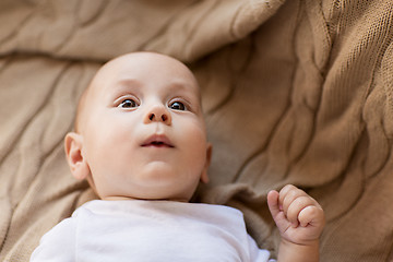 Image showing sweet little baby boy lying on knitted blanket