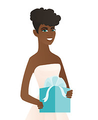 Image showing Woman in a white bridal dress holding a gift box.