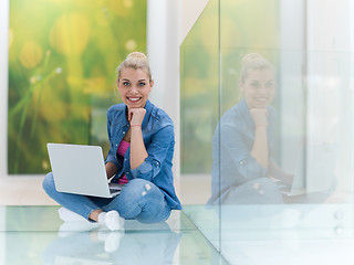 Image showing young woman using laptop computer on the floor