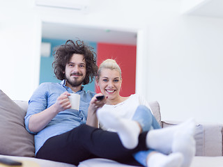 Image showing Young couple on the sofa watching television