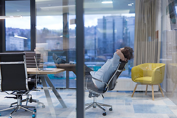 Image showing young businessman relaxing at the desk