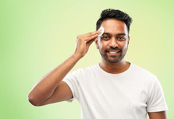 Image showing smiling indian man cleaning face with cotton pad