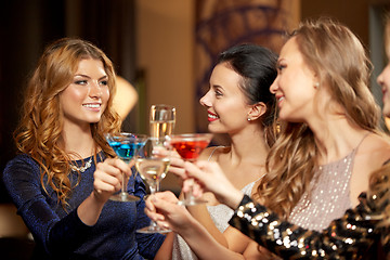 Image showing happy women clinking glasses at night club