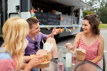 Image showing happy friends with drinks eating at food truck