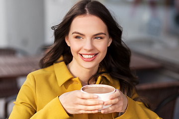 Image showing teenage girl drinking hot chocolate at city cafe