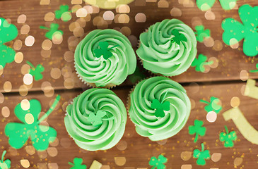 Image showing green cupcakes and shamrock on wooden table