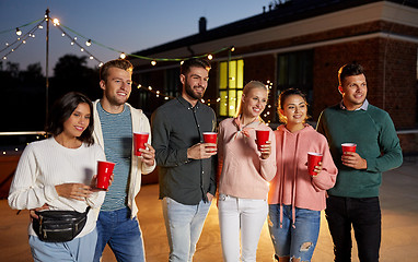 Image showing friends with party cups on rooftop at night