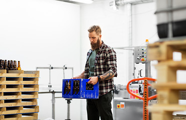 Image showing man with bottles in box at craft beer brewery