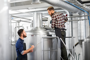 Image showing men with clipboard at brewery kettle or beer plant