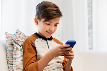 Image showing happy smiling boy with smartphone at home