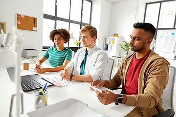 Image showing happy creative workers with laptops at office