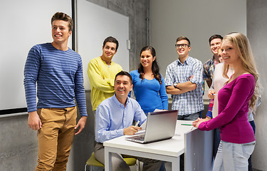 Image showing students and teacher with papers and laptop