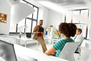 Image showing man showing tablet pc to creative team at office