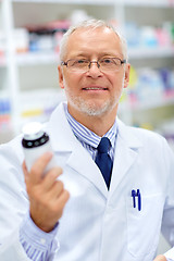 Image showing senior apothecary with drug at pharmacy