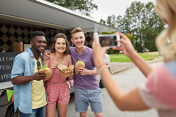 Image showing woman photographing friends eating at food truck