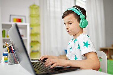 Image showing boy in headphones playing video game on laptop