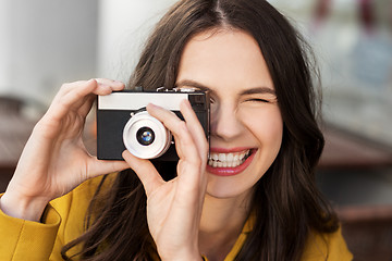 Image showing happy young woman with film camera outdoors