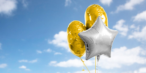 Image showing three gold and silver helium balloons on white