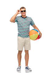 Image showing smiling young man in sunglasses with beach ball