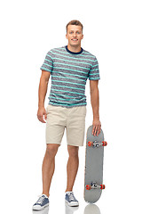 Image showing smiling young man with skateboard over white