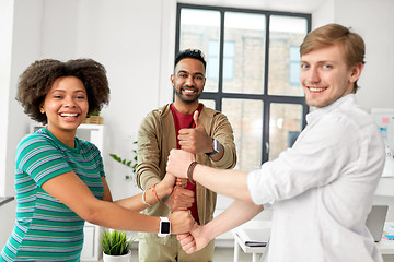 Image showing happy creative team making high five at office