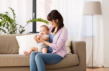 Image showing happy young asian mother with little baby at home