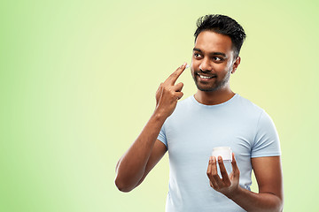 Image showing happy indian man applying cream to face