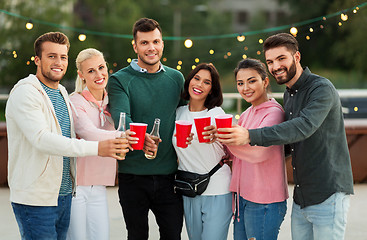 Image showing friends with drinks in party cups at rooftop