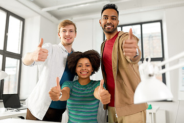 Image showing happy creative team showing thumbs up at office