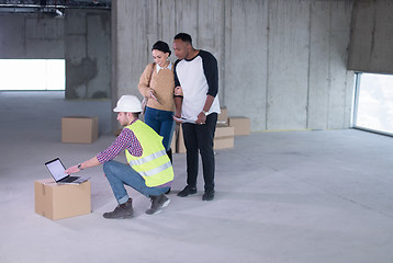 Image showing engineer showing house design plans to a young multiethnic coupl