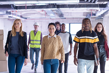 Image showing young multiethnic business people walking through unfinished sta