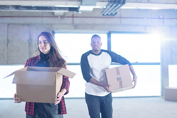 Image showing multiethnic business team carrying cardboard boxes