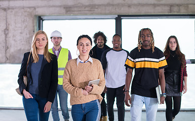 Image showing young multiethnic business people walking through unfinished sta