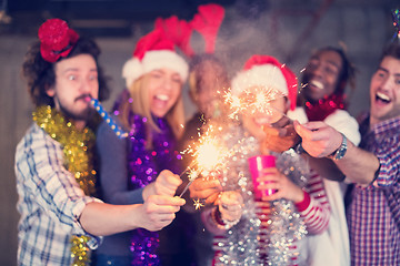 Image showing multiethnic group of casual business people lighting a sparkler