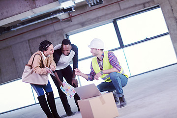 Image showing engineer showing house design plans to a young multiethnic coupl