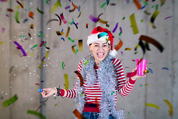 Image showing business woman wearing a red hat and blowing party whistle