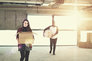 Image showing multiethnic business team carrying cardboard boxes