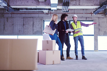 Image showing architect showing house design plans to a young couple