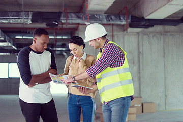 Image showing architect showing house design plans to a young multiethnic coup