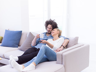 Image showing Young couple on the sofa watching television