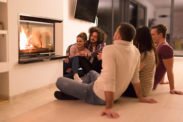 Image showing multiethnic couples sitting in front of fireplace