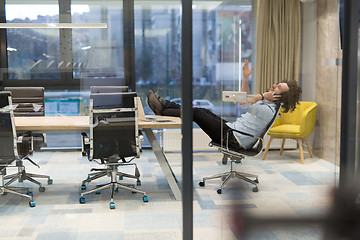 Image showing young businessman relaxing at the desk