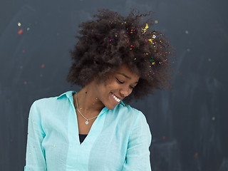 Image showing black woman blowing confetti in the air