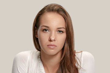 Image showing The serious business woman standing and looking at camera against gray background.